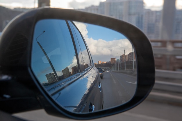 Reflexão no espelho lateral de um carro ao dirigir pela cidade