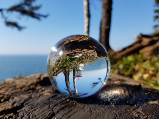 Foto reflexión de la bola de cristal en el vidrio contra el cielo azul