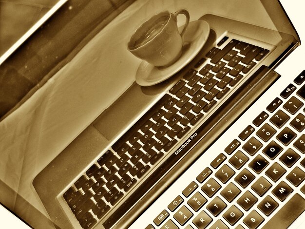 Reflexión del café en la computadora portátil en la mesa