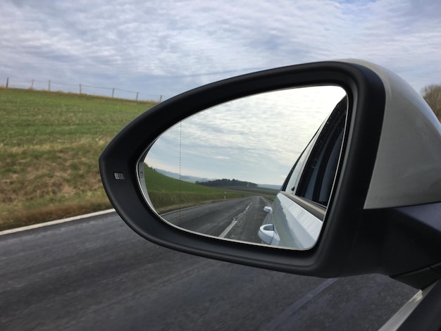 Reflexión de la carretera en el espejo lateral del automóvil