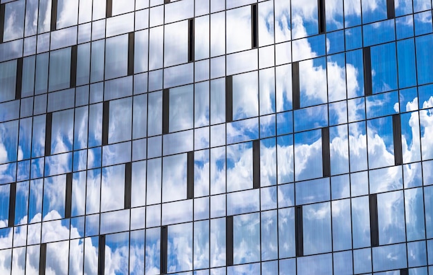 Reflexión en el cielo azul del edificio con nubes ligeras