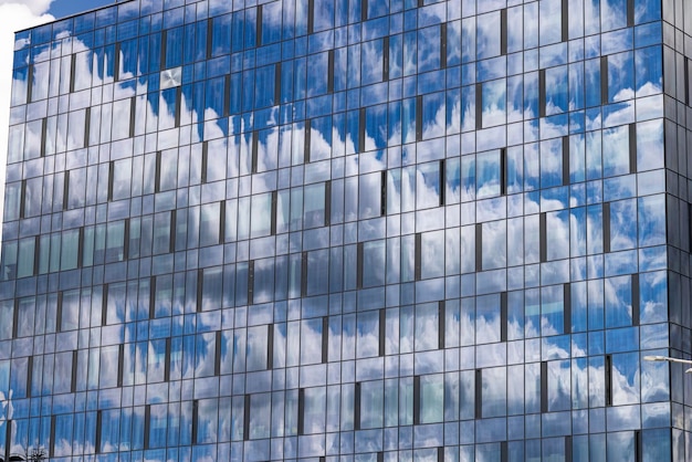 Reflexión en el cielo azul del edificio con nubes ligeras