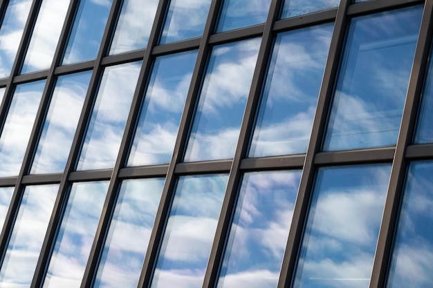 Reflexión del cielo y las nubes en las ventanas del edificio moderno Edificio de vidrio exterior