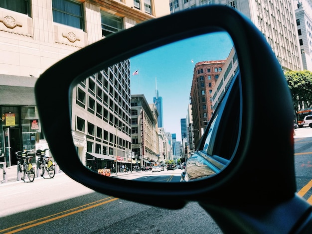 Foto reflexión de la ciudad en el espejo lateral