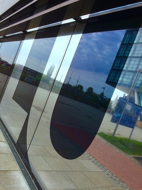 Foto reflexion des fußweges gegen den himmel auf einem glasgebäude
