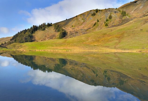 Reflexion des Himmels und der Landschaft auf dem Wasser eines alpinen Bergsees