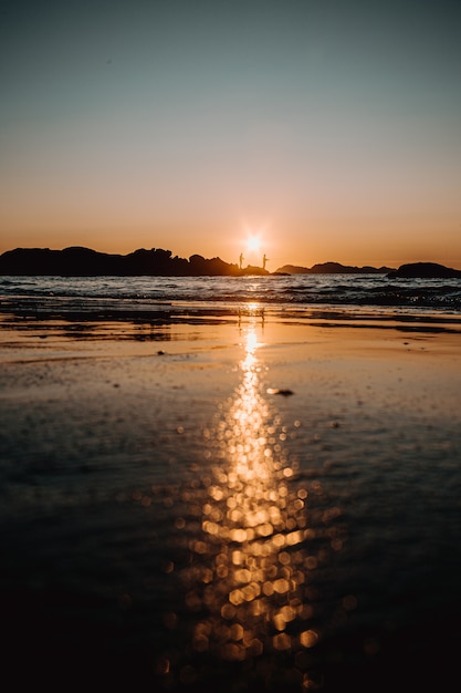 Reflexion des Sonnenuntergangs auf dem Sand am Strand