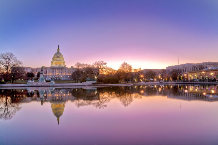 Foto reflexión de un edificio iluminado en el río al atardecer