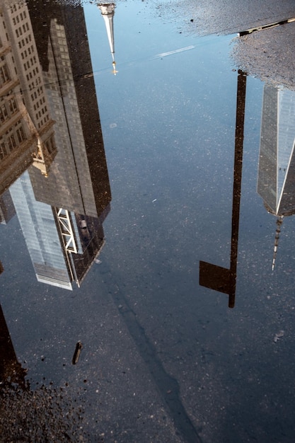 Foto reflexión de los edificios en el charco en la carretera