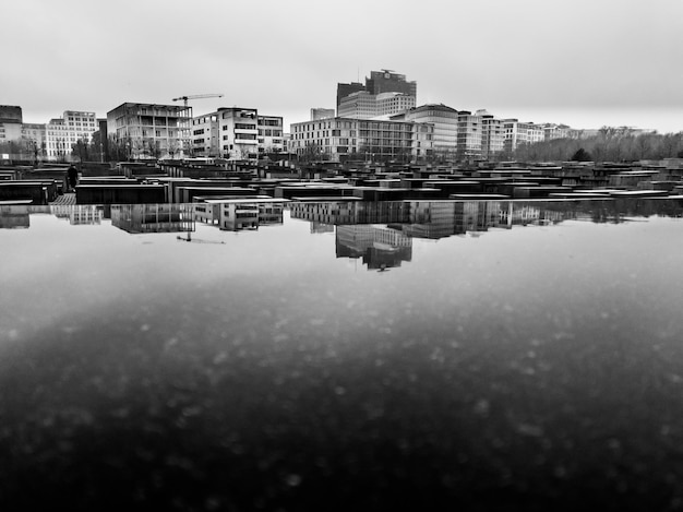 Foto reflexión de los edificios en el lago contra el cielo