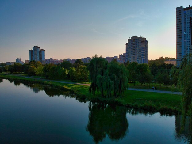 Reflexión de los edificios en el río en la ciudad contra el cielo