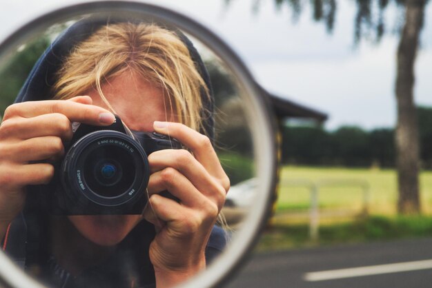 Reflexion einer fotografierenden Frau