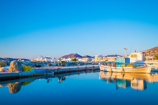 Reflexion eines alten Fischerbootes vor Anker am kleinen Dock Insel Paros Griechenland Schöne Aussicht auf Fischerboot mit Reflexion über die Meeresoberfläche bei Sonnenuntergang