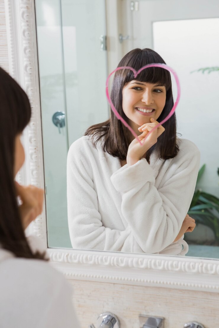 Foto reflexión de hermosa mujer joven en espejo con corazón