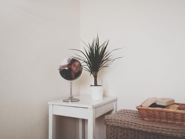 Foto reflexión de la mujer en el espejo en la mesa en casa