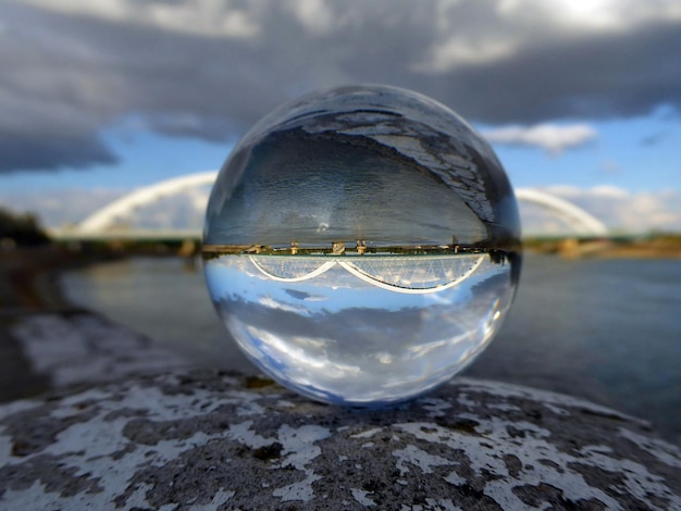 Reflexión del puente en la bola de la lente en un día nublado