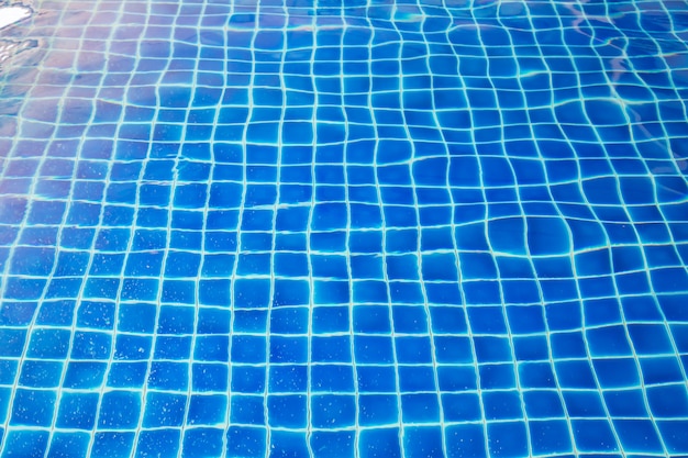 Reflexión del sol de piscina con fondo de mosaico azul