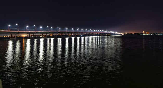 Reflexion von hellen Laternen im Dnjepr unter der Brücke