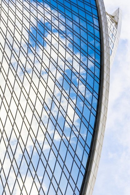 Reflexion von Himmel und Wolken in Glasspiralwelle mit Biegefassadenfenstern von Finanzwolkenkratzern