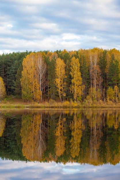 Reflexiones de árboles de follaje colorido en el agua tranquila del estanque en un hermoso día de otoño. Un lugar tranquilo y hermoso para relajarse.