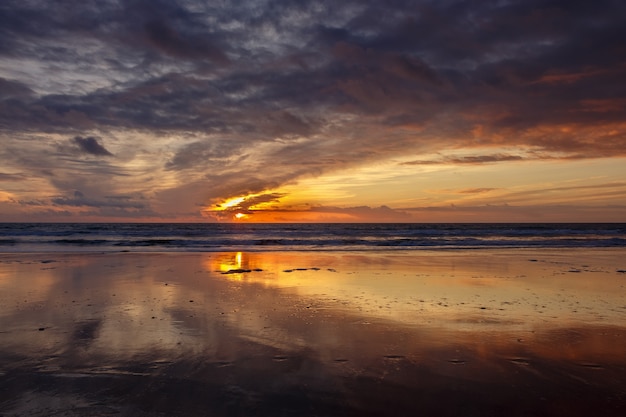 Reflexiones en la orilla de la playa al atardecer