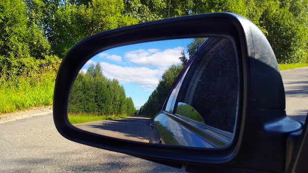 Reflexo da estrada no espelho do carro