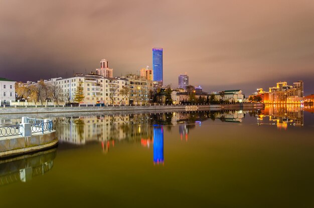 Reflexo das casas da cidade noturna no rio.