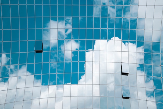 Reflexo de céu azul e nuvens em um edifício moderno e alto.