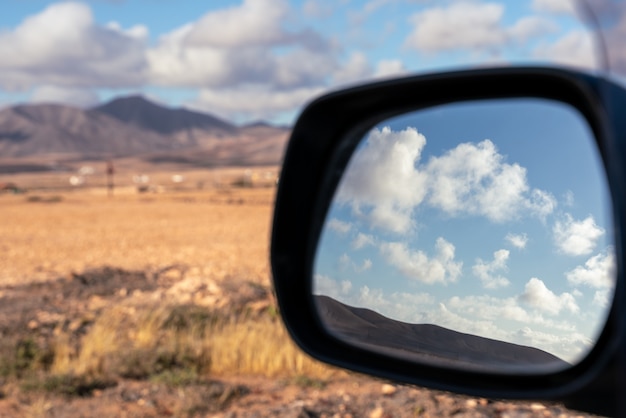 Reflexo de nuvens no espelho retrovisor de um carro - foco seletivo.