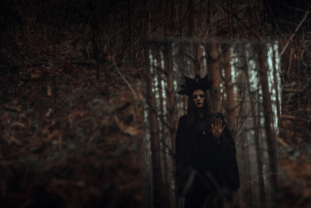 Reflexo de uma terrível bruxa negra em um espelho em uma floresta escura