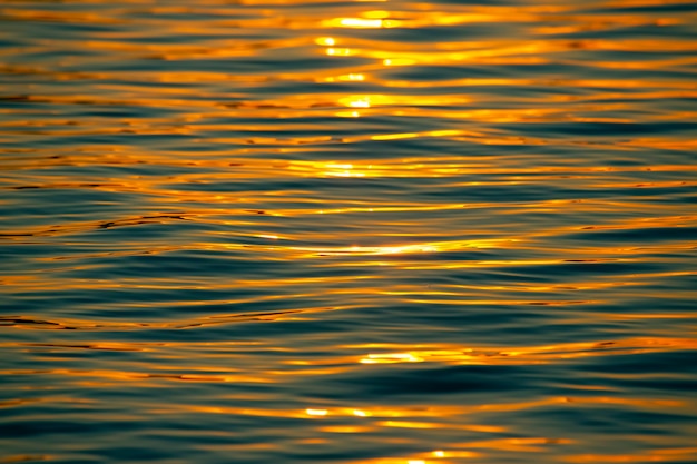 Reflexo do sol poente em uma onda de água. Textura de fundo natural