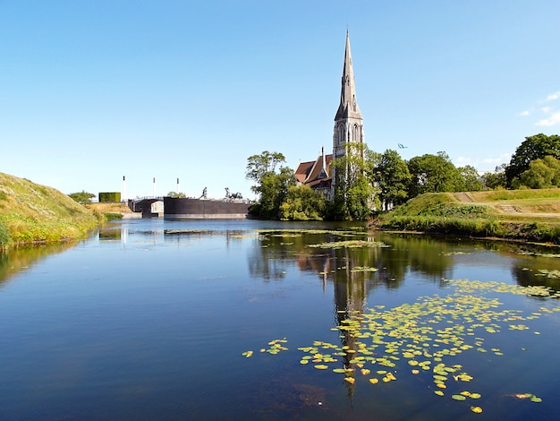 Reflexões da Igreja de St. Alban na lagoa do Kastellet (Citadel) em Copenhague, na Dinamarca