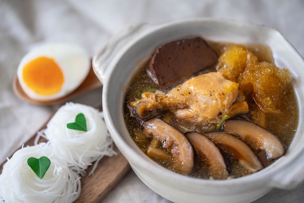 Refogado de peixe em sopa de molho vermelho com frango, broto de bambu e cogumelos Shiitake