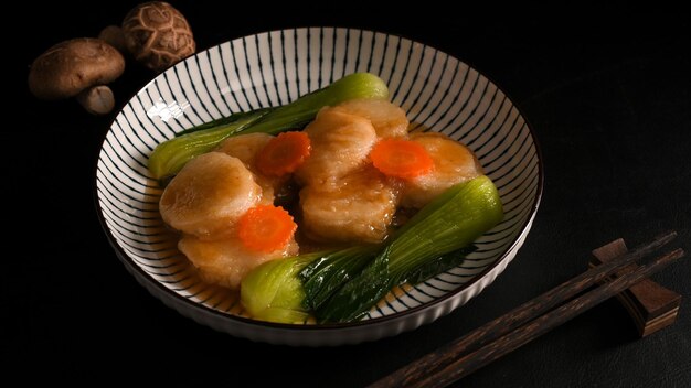 Refogue a coalhada de feijão com molho asiático especial e vegetais em um prato de porcelana. Conceito de comida asiática.