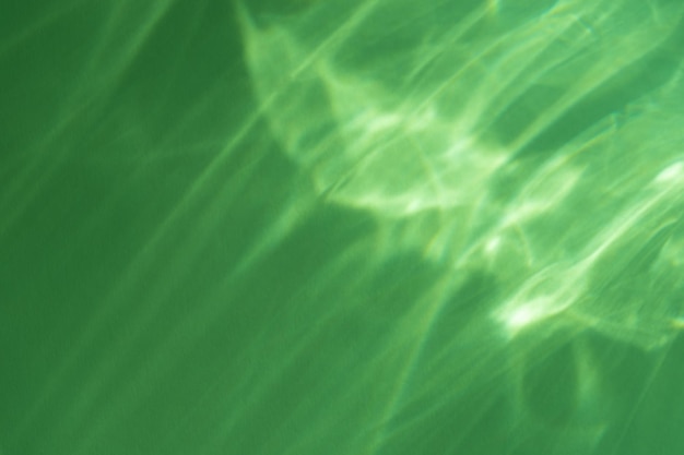 Refração de luz de efeito cáustico na maquete de foto de sobreposição de parede verde raios de sol borrados refratando através de prisma de vidro com sombra Silhueta de refração de luz natural abstrata na superfície da águaxA