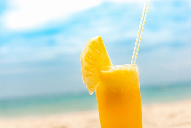 Refrescante bebida de jugo de frutas de piña tropical en la playa de verano