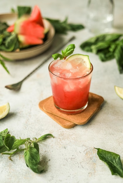 Refrescante bebida saludable sin alcohol con hielo de hojas de sandía, lima y albahaca