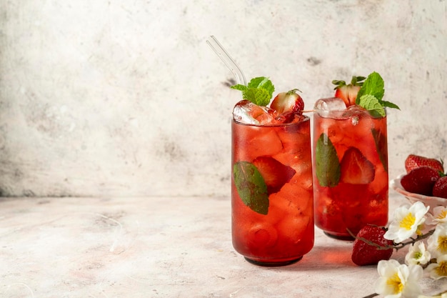 Refrescante bebida de verano de fresa en vaso con cubitos de hielo y hojas de menta Espacio de copia