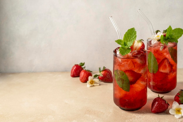 Refrescante bebida de verano de fresa en vaso con cubitos de hielo y hojas de menta Espacio de copia