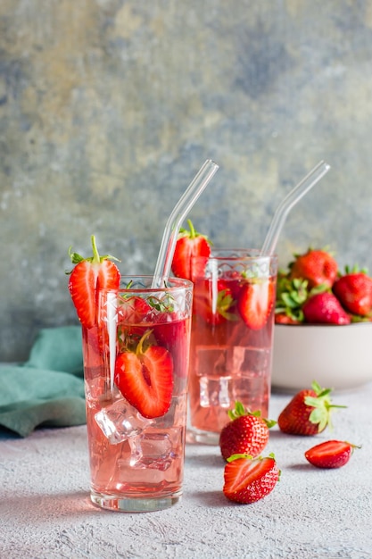 Refrescante cóctel con fresas en vasos con una pajita sobre la mesa Vista vertical