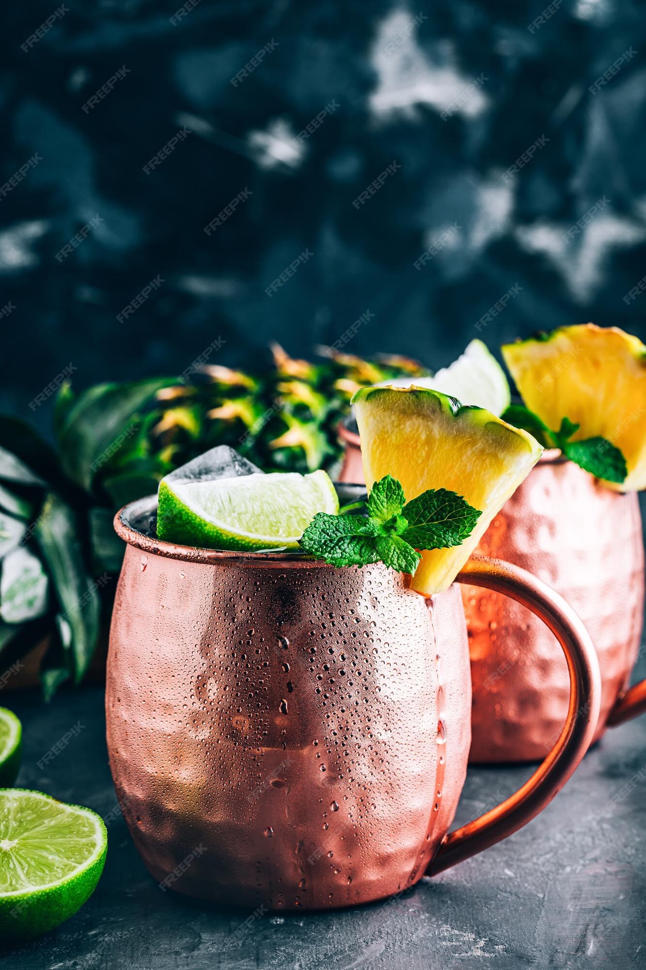 Refrescante cóctel iced cold moscow mule con lima y piña sobre fondo oscuro  | Foto Premium