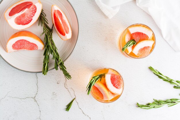 Refrescante cóctel de pomelo con romero en copas sobre la mesa bebida casera Vista superior