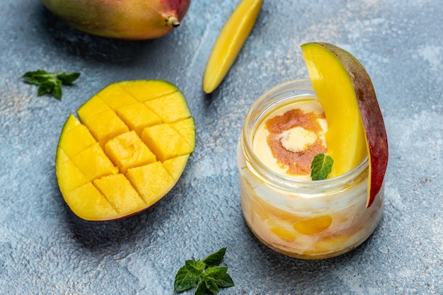 Refrescante helado de mango con hojas de menta y mango fresco servido en un frasco de vidrio Fondo de recetas de alimentos Cerrar