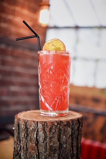 Una refrescante limonada de verano hecha de fresas, frambuesas, pomelo o grosellas rojas. Cóctel rojo en vidrio en el interior