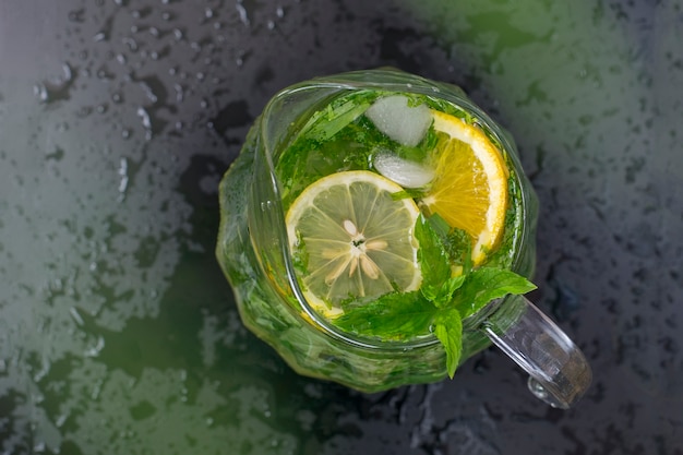 Refrescante limonada de verano en un vaso transparente, menta, estragón, limón. Tonificado