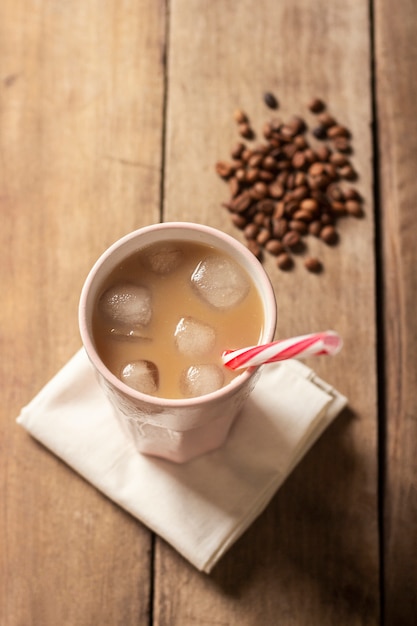 Refrescante y vigorizante café helado en un vaso sobre una superficie de madera. Concepto de cafetería, calmar la sed, verano. Vista plana, vista superior