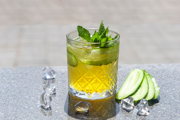 Refrescantes cócteles fuertes de verano con una rodaja de limón. Bebida alcoholica. Decorado con una ramita de menta, cítricos y cubitos de hielo. En el bar.