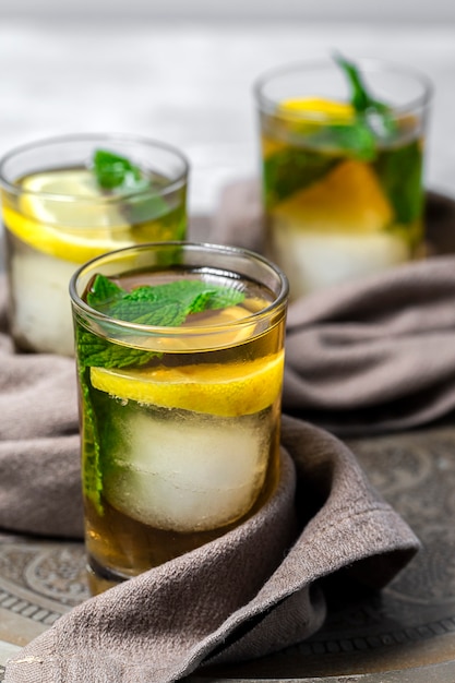 Refrescantes vasos de té con hielo, menta y rodajas de limón.