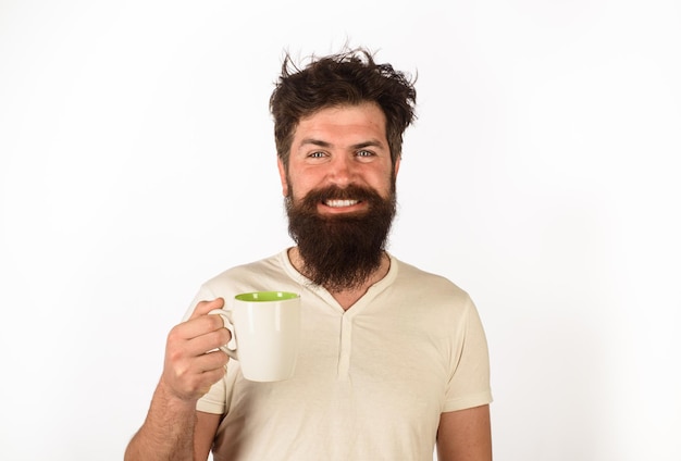 Refresco e energia homem feliz tomando uma xícara de café na cozinha sorrindo homem segurando uma caneca com água quente