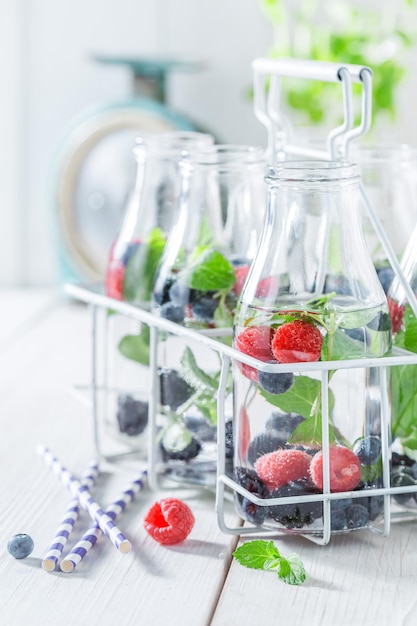 Refresco espumoso en botella con frambuesas, arándanos y moras